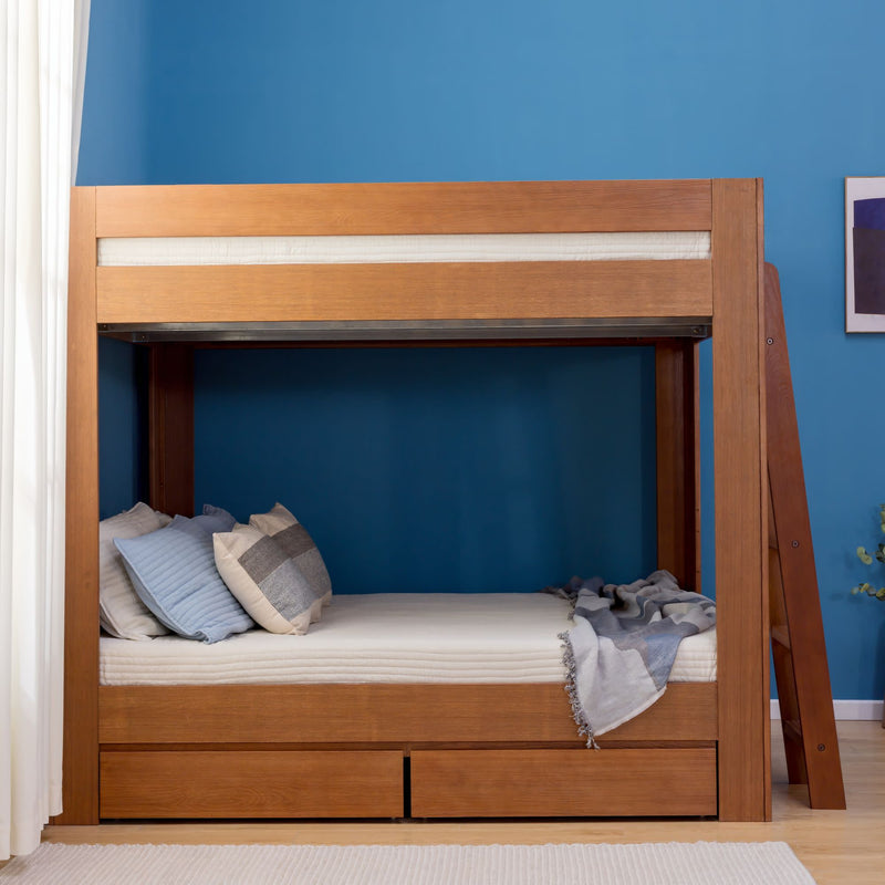 Modern wooden bunk bed with built-in storage drawers, ladder and cozy pillows and throw against blue accent wall