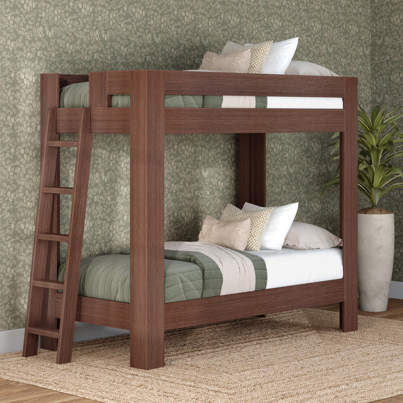 Modern solid wood twin-over-twin bunk bed with ladder, green quilted bedding and neutral pillows in cozy farmhouse bedroom with floral wallpaper and potted plant