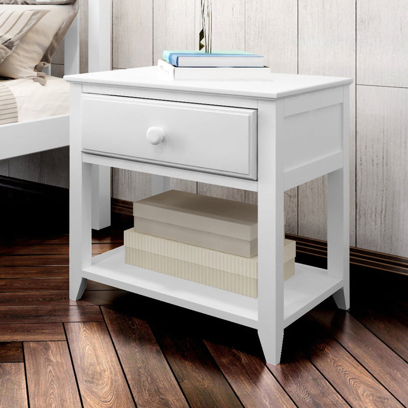 White wooden nightstand with a drawer and shelf, styled with books and decor, on hardwood floor in bedroom setting.