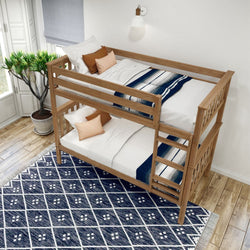 Wooden bunk bed with white and navy bedding in a bright room with plant and patterned rug.