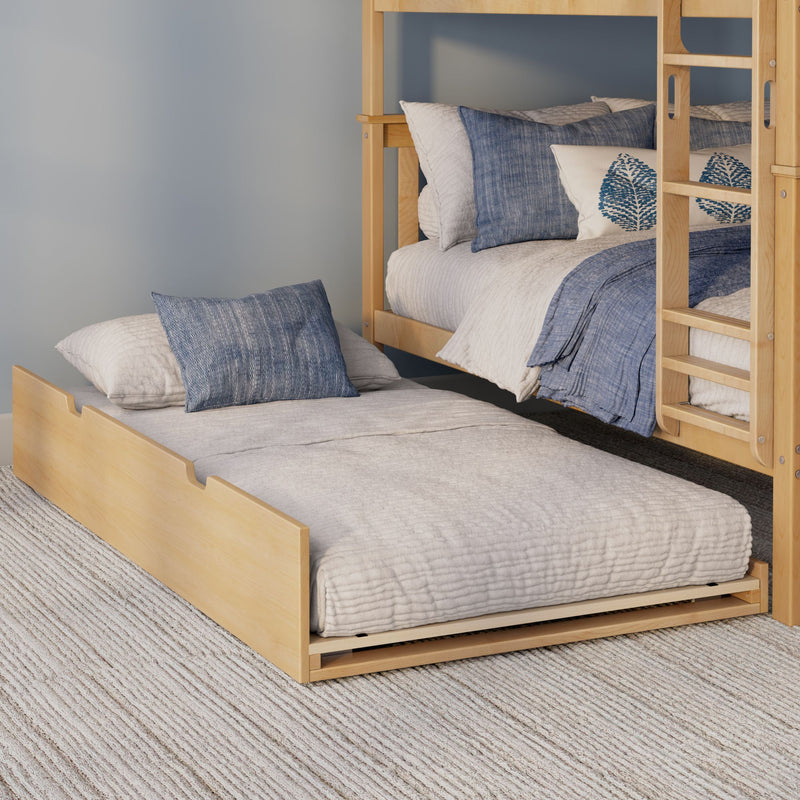 Light wood bunk bed with pull-out trundle, blue and white quilted bedding and decorative blue pillows in a modern bedroom