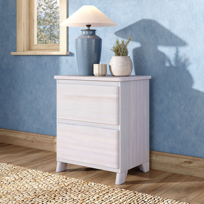 Bedroom decor scene with whitewashed bedside table, blue ceramic table lamp, textured blue wallpaper, potted plant and natural wood window frame