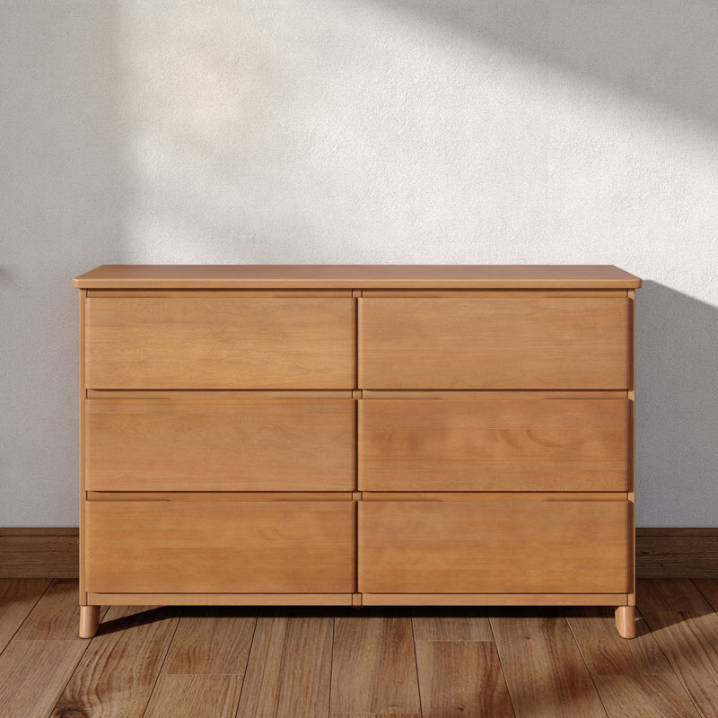 Minimalist light-wood six-drawer dresser on hardwood floor against a neutral wall, modern bedroom storage chest for small-space interiors