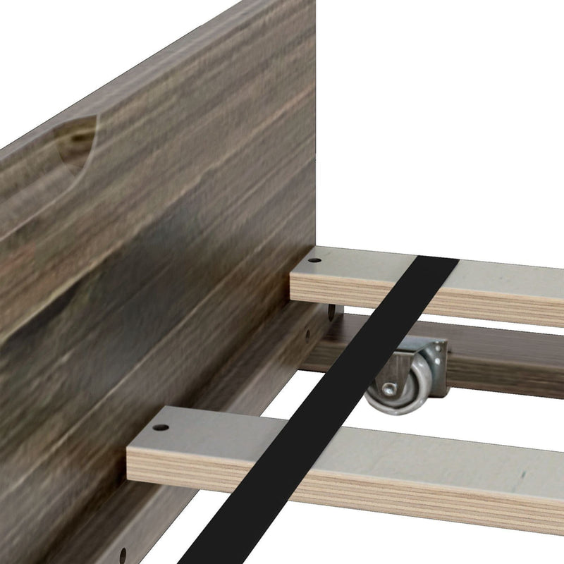 Close-up of wooden bed frame with plywood slats, black center support strap and metal caster wheel on center support rail