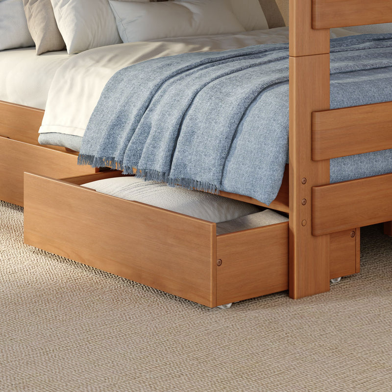 Natural wood trundle bed with pull-out storage drawer, cozy blue woven throw blanket, white sheets and beige pillows on a textured woven rug