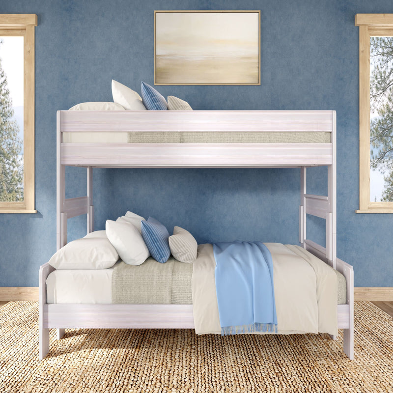 White wooden bunk bed with blue throw and decorative pillows in a coastal-style bedroom with blue walls and natural jute rug