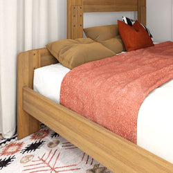 Modern wooden bed frame with cozy pillows and a red blanket, perfect for stylish bedroom decor.