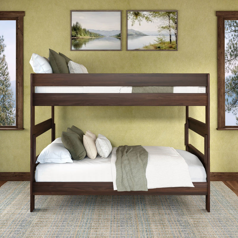 Dark wood full-over-full bunk bed in bright bedroom with green walls, layered pillows and sage throw, coastal wall art