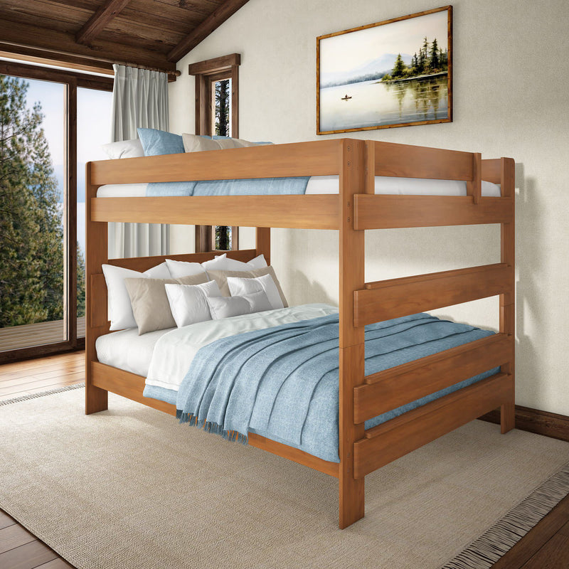 Solid wooden bunk bed with blue bedding in a rustic farmhouse bedroom overlooking pine trees and a lake