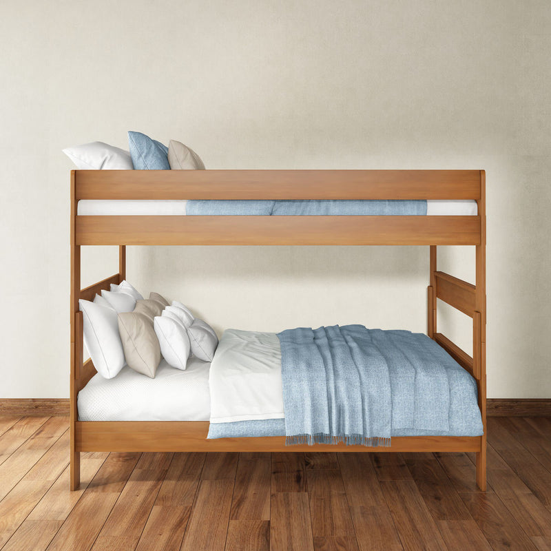 Natural wood bunk bed with blue blankets and white pillows in a minimalist bedroom on hardwood floor