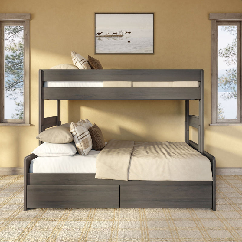 Rustic dark wood bunk bed with beige linens and plaid pillows in a cozy sunlit bedroom with lake artwork and narrow windows
