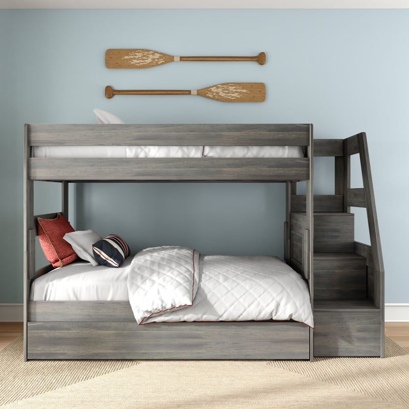 Gray wooden bunk bed with built-in staircase and storage in coastal kids' bedroom, white quilt and striped pillows beneath decorative wooden oars