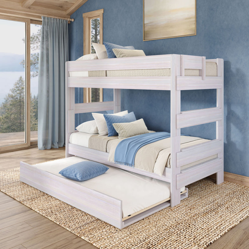 Whitewashed wooden twin-over-twin bunk bed with pull-out trundle, blue and beige bedding in coastal-style bedroom with large window overlooking lake and pine trees, natural jute rug on hardwood floor