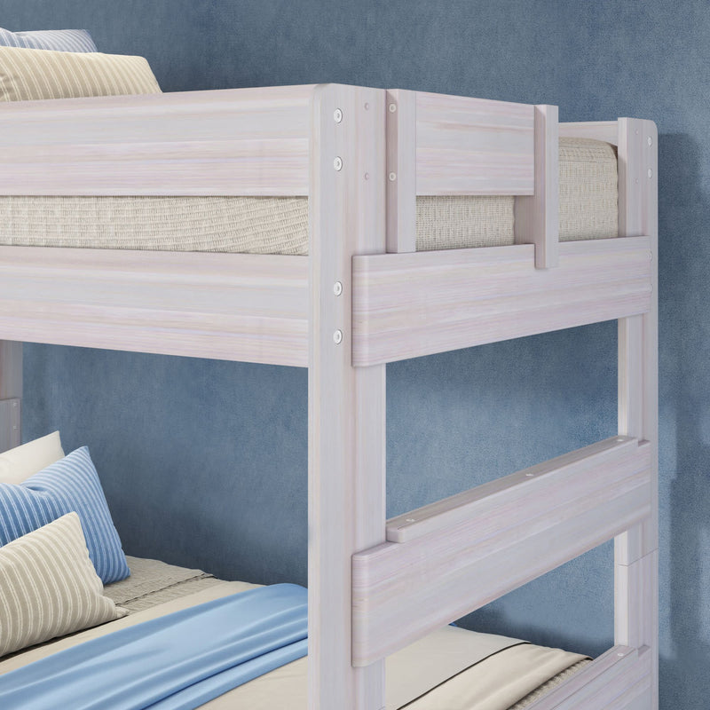 Whitewashed wooden bunk bed close-up with light blue bedding and striped pillows in a modern kids' bedroom against a blue textured wall