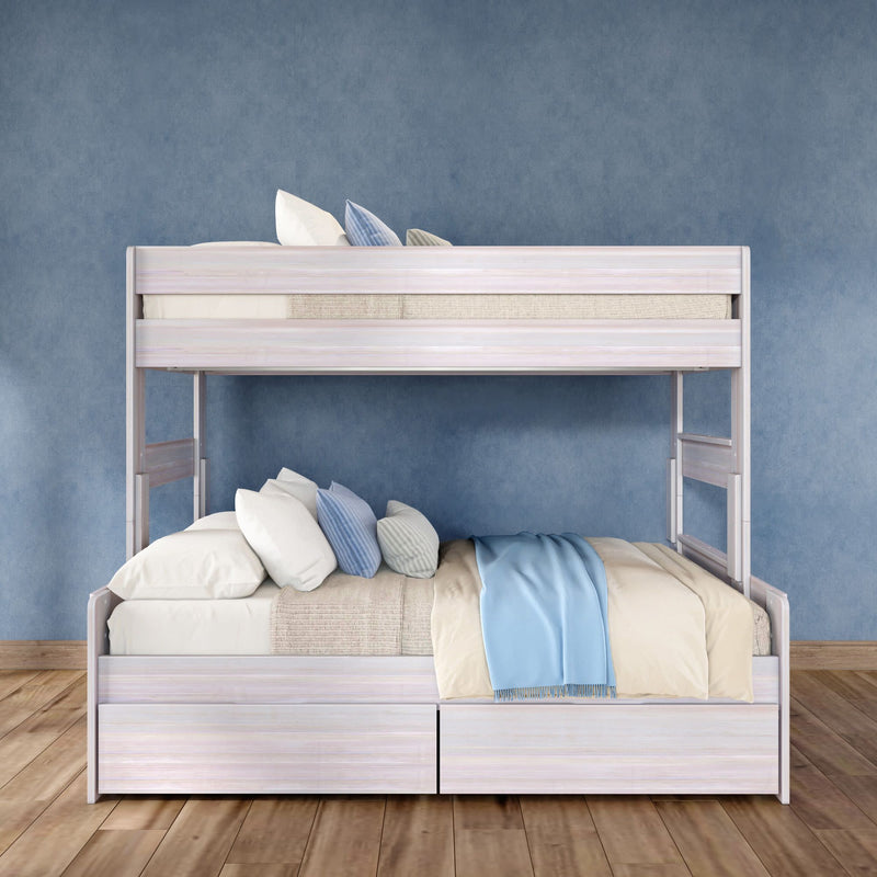 Whitewashed wooden twin-over-full bunk bed with under-bed storage drawers, cream and blue bedding and pillows against a textured blue wall on hardwood floor, modern kids' bedroom furniture