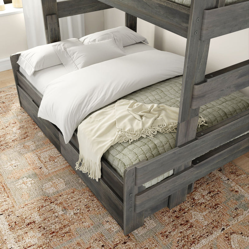 Dark wood bunk bed with white linens and a cozy blanket on a patterned rug in a modern bedroom.