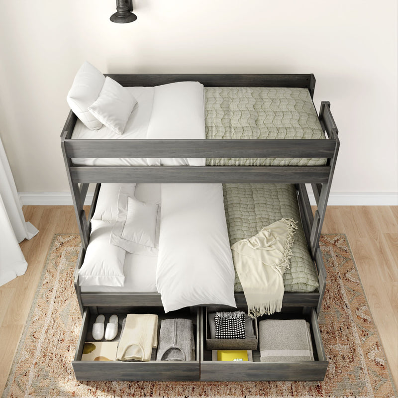 Modern gray bunk bed with storage drawers on a hardwood floor, featuring white and beige bedding, a cozy throw, and an elegant rug.