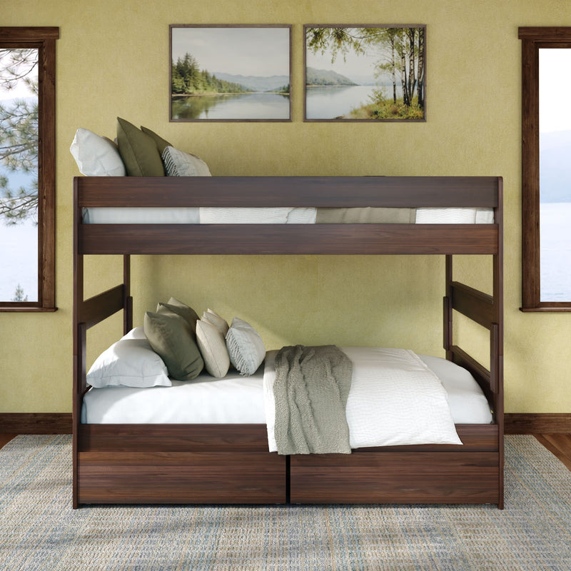 Dark walnut twin-over-full bunk bed with under-bed storage drawers, white linens and green accent pillows in a cozy rustic bedroom with lake-view windows and landscape wall art