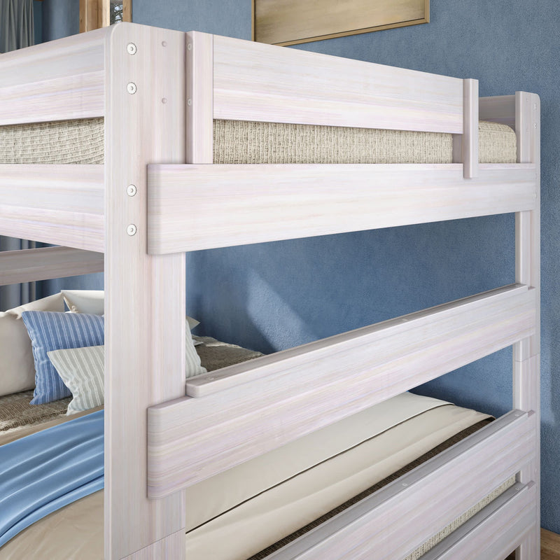 Whitewashed wooden twin-over-twin bunk bed with safety rail, beige mattresses, striped pillows and blue accent wall in a modern coastal bedroom