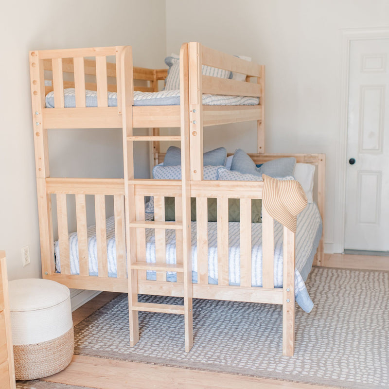 Light natural wood bunk bed with ladder and blue-striped bedding in a neutral kids' bedroom with woven rug