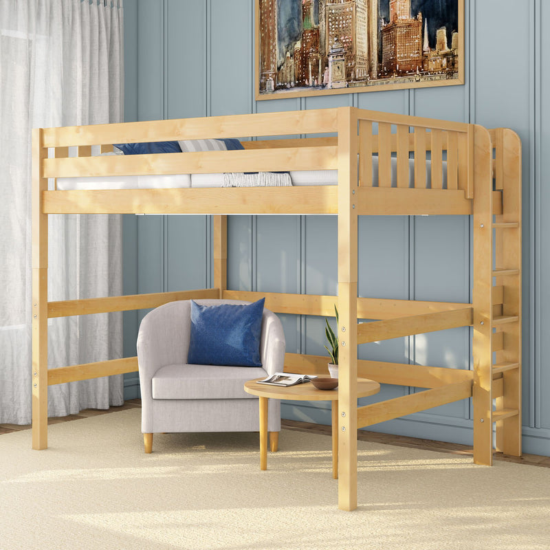 Natural wood loft bed with side ladder over cozy reading nook featuring a light gray armchair with blue pillow, round wooden table, and light blue paneled wall