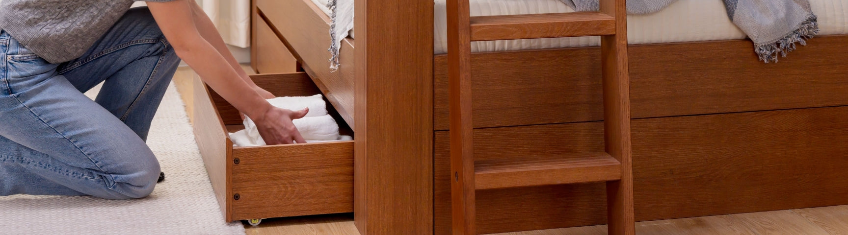 Rustic wooden top bunk bed with white bedding, green throw and knitted Christmas stockings hanging in a neutral farmhouse kids bedroom