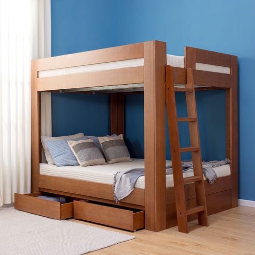 Modern wooden bunk bed with ladder and pull-out storage drawers against a blue accent wall in a bedroom.