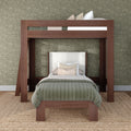 Wooden loft bunk bed with lower twin bed, olive green quilted bedding and decorative pillows against floral green wallpaper and jute rug in a modern kids' bedroom