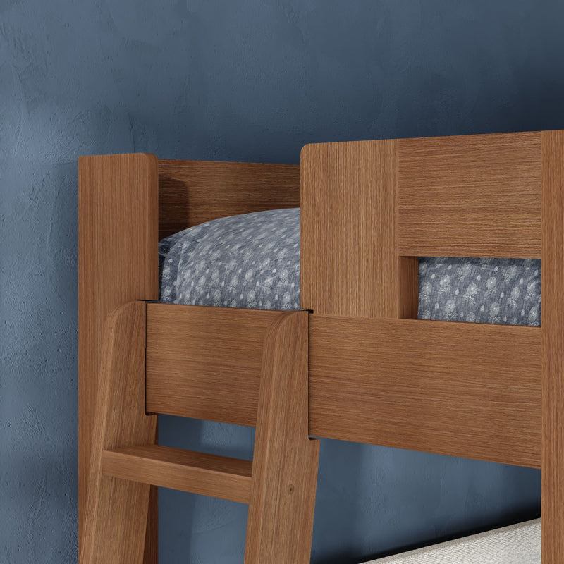 Wooden bunk bed with ladder and guardrail, blue patterned bedding and textured navy bedroom wall