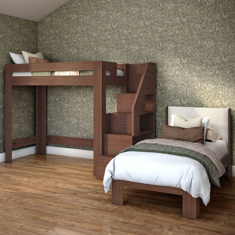 Modern wooden loft bed with built-in staircase and storage paired with a twin bed, green floral wallpaper and hardwood floor in a cozy bedroom