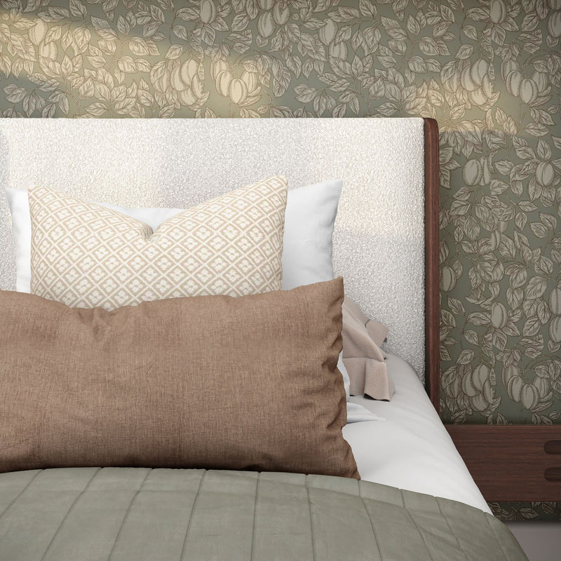 Textured white upholstered headboard with patterned cream and brown accent pillows, sage green floral wallpaper and wooden nightstand
