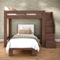 Solid wood loft bed with built-in staircase and twin lower bed styled with neutral bedding against green floral wallpaper on a hardwood floor