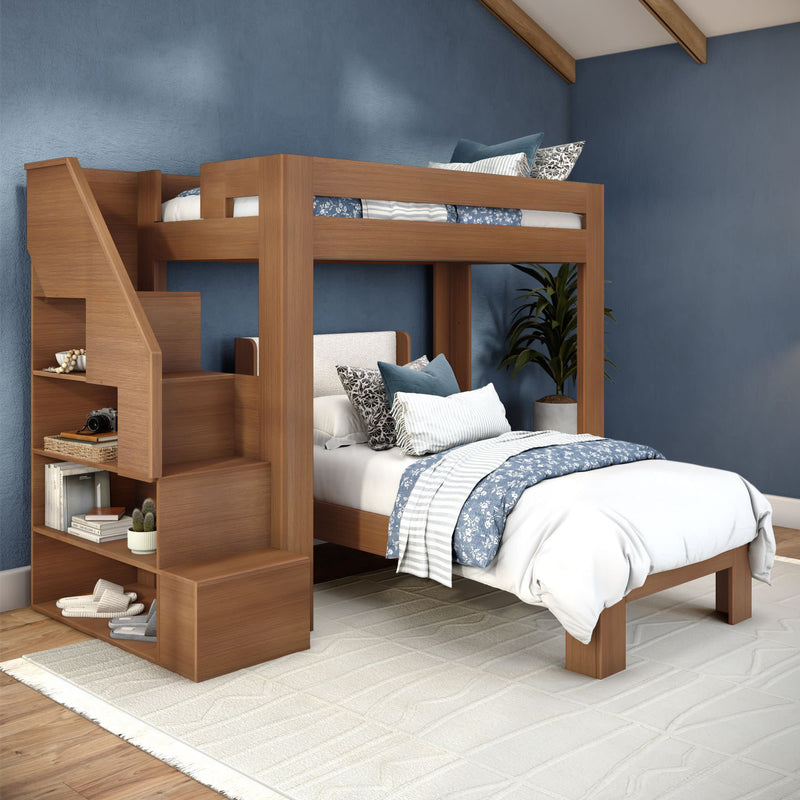 Modern wooden bunk bed with built-in staircase and shelving in a blue-accent bedroom, white and blue patterned bedding, decorative pillows, potted plant and light rug on hardwood floor