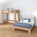 Modern minimalist bedroom with natural wood loft bed and platform full-size bed, ladder, blue patterned bedding and hardwood floor