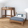 Modern minimalist bedroom with a wooden twin loft bed with ladder and matching wooden platform single bed frame, blue patterned bedding, decorative pillows, hardwood floor and white walls