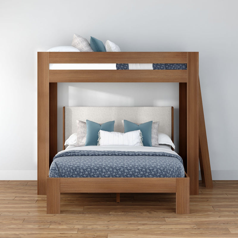 Modern wooden bunk bed frame with upholstered lower headboard, blue patterned bedding and teal and white accent pillows in a minimalist bedroom with hardwood floor and white wall
