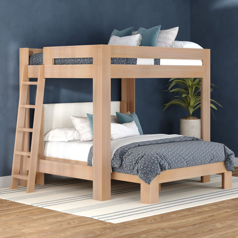 Modern natural wood loft bunk bed with ladder, blue patterned bedding and accent pillows in a navy-accent bedroom — space-saving bedroom furniture