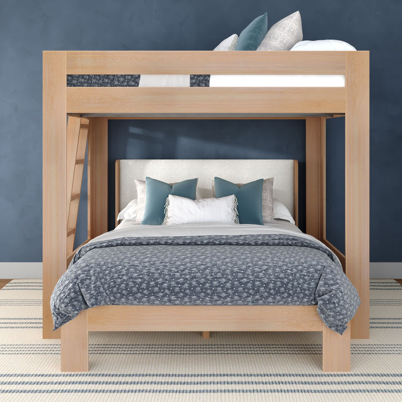 Light-wood loft bunk bed with full lower bed and twin upper bed, blue-gray quilted bedding, teal decorative pillows, navy accent wall and striped rug
