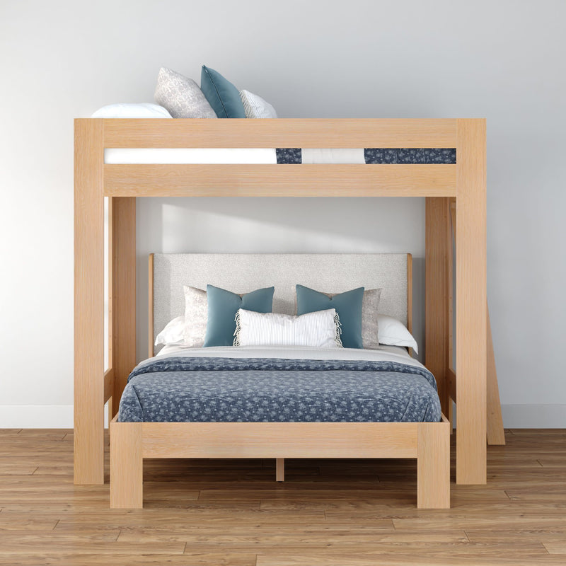 Modern natural oak bunk bed with full lower bed and twin upper bunk, upholstered headboard, blue bedding and pillows on hardwood floor