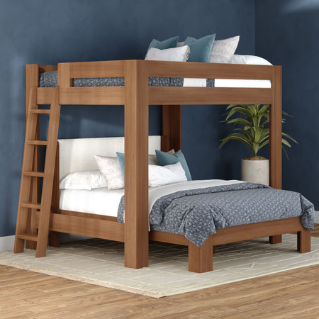 Modern wooden twin-over-full bunk bed with ladder and oak finish in a navy blue bedroom, gray-blue bedding, area rug, and potted plant