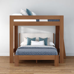Modern solid-wood loft bunk bed with blue patterned bedding, upholstered headboard and decorative pillows on hardwood floor