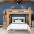 Light wood twin-over-full bunk bed with staircase storage, blue floral bedding and navy accent wall in a modern coastal bedroom