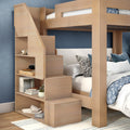 Space-saving wooden bunk bed with storage staircase and built-in shelves, twin-over-full design with blue accent wall and patterned bedding