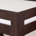 Close-up of dark wood bed frame corner on a modern platform bed with white textured mattress, solid wood bedroom furniture detail