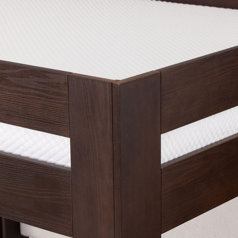 Close-up of dark wood bed frame corner on a modern platform bed with white textured mattress, solid wood bedroom furniture detail