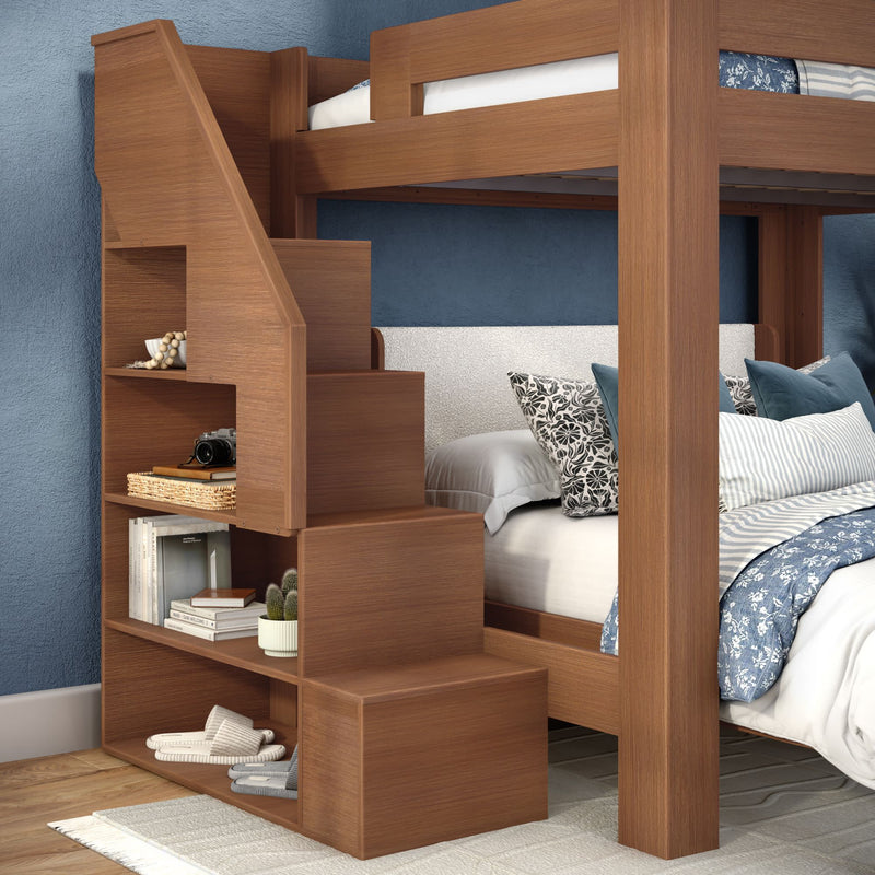 Wooden bunk bed with built-in storage staircase and open shelves, space-saving twin loft bed with blue floral bedding, decorative pillows and bedroom decor