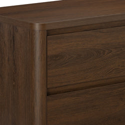 Dark brown wood dresser close-up showing walnut-finish drawers, rounded corner and natural wood grain texture — modern rustic bedroom furniture
