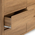 Close-up of open oak wood dresser drawer with metal slide glides in a natural oak finish, modern bedroom storage furniture