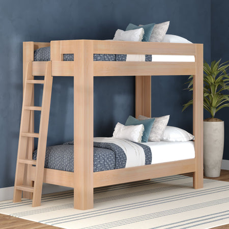 Solid wood twin-over-twin bunk bed with ladder in natural finish, blue bedding and decorative pillows in a modern kids' bedroom with navy textured wall, striped rug and potted plant — space-saving bunk bed design