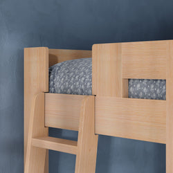 Close-up of light wood bunk bed ladder and guardrail with gray patterned mattress and bedding against a blue textured wall